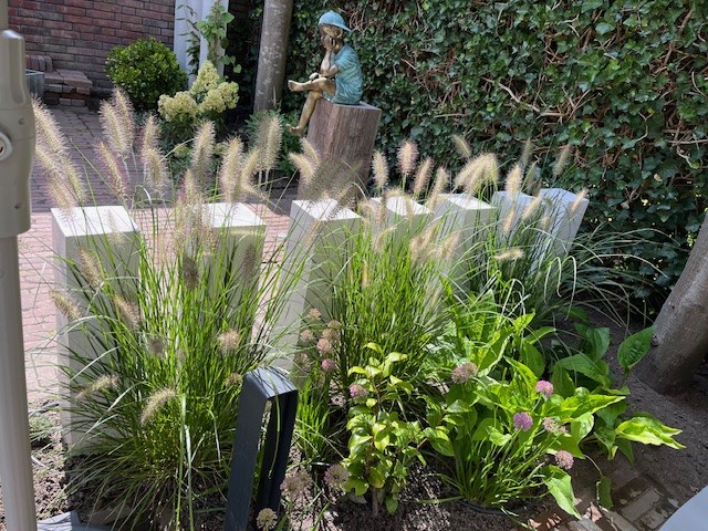 Beeld brons zittende jongen met pet