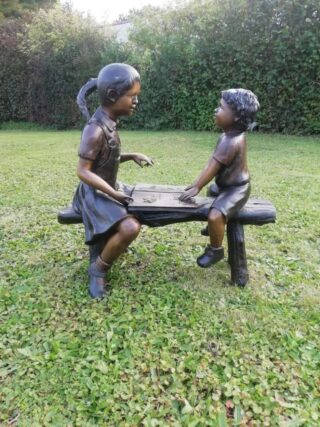 bronze boy and girl on bench - eliassen.nl