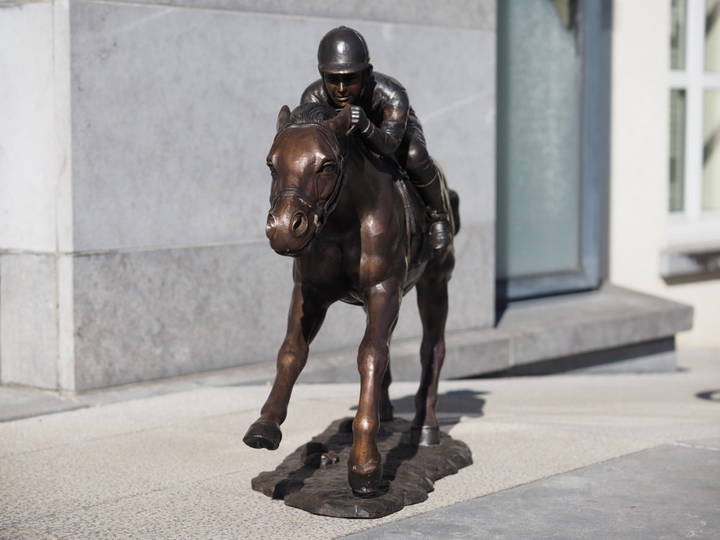 Bronzen dravend paard met jockey