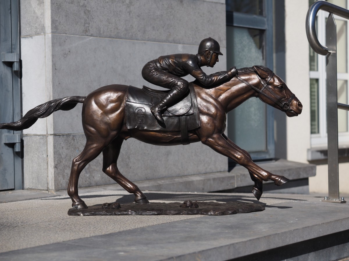 Bronzen dravend paard met jockey